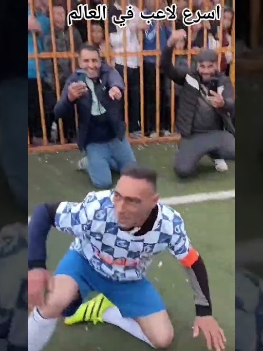 Choucha on his knees, men filming him